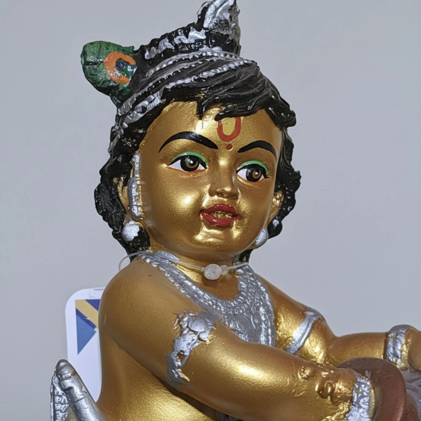 Gold-colored statue with intricate details on a gray background