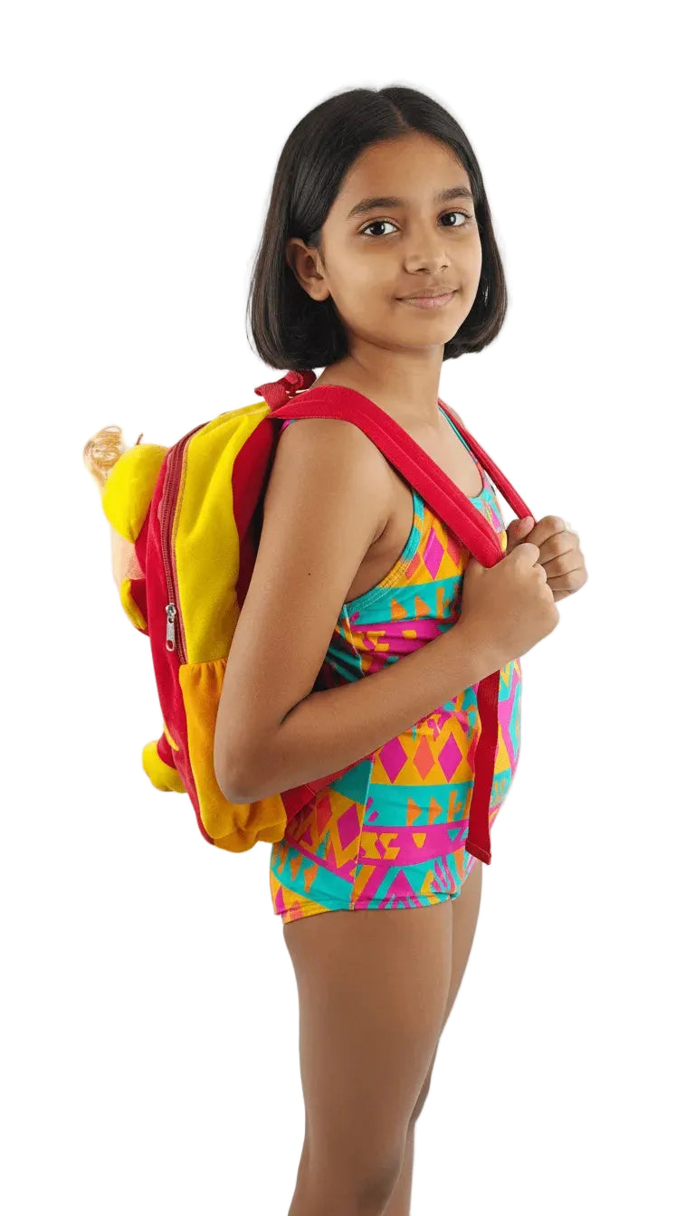 Young girl in a colorful swimsuit with a red and yellow backpack on a white background