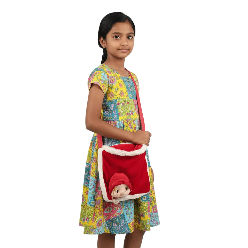 Young girl holding a red bag with a teddy bear, wearing a colorful dress on a white background