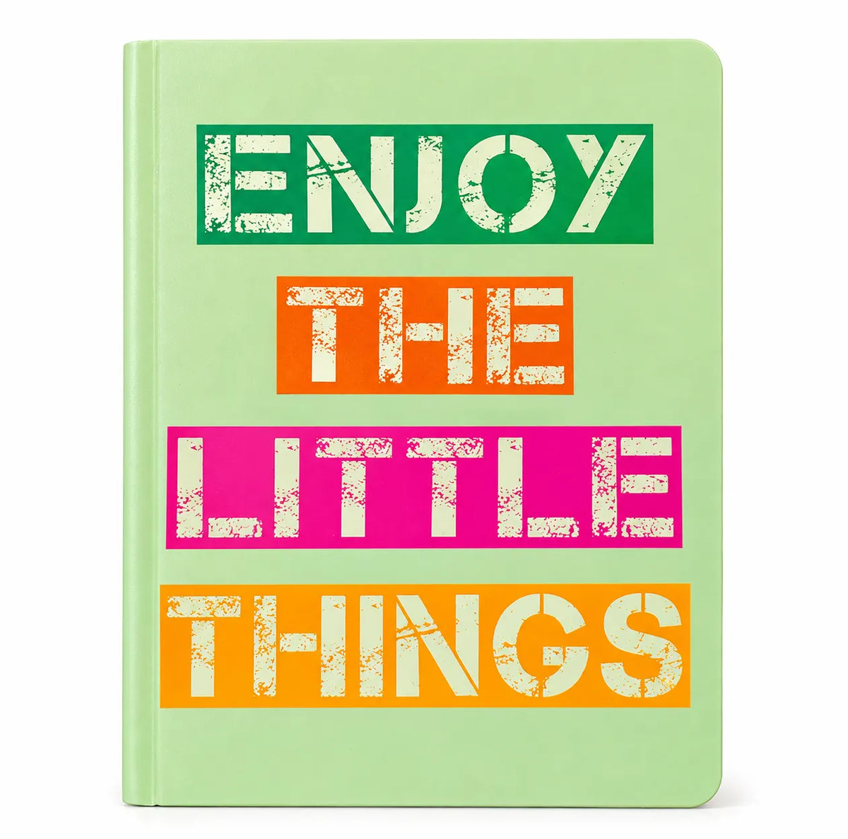 A hardcover notebook with a light green cover featuring the quote 'ENJOY THE LITTLE THINGS' in bold, distressed white letters set against green, orange, and pink blocks.