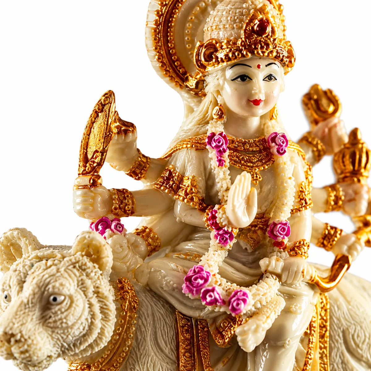 A detailed figurine of a Hindu goddess riding a white elephant, decorated with ornate gold jewelry and pink flower garlands, set against a plain white background.