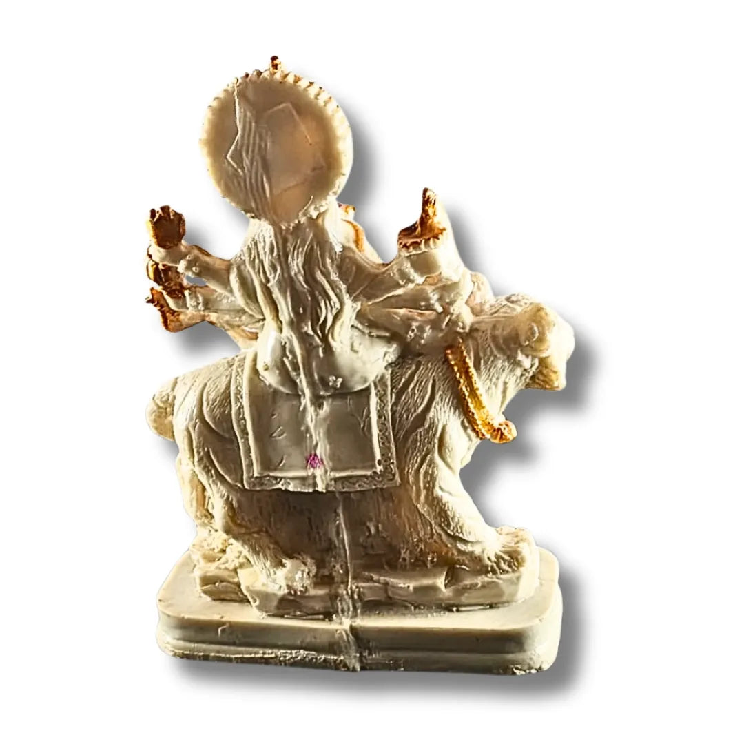 A small beige and cream-colored statue of a multi-armed deity seated on a Lion , shown against a plain white background with a drop shadow.