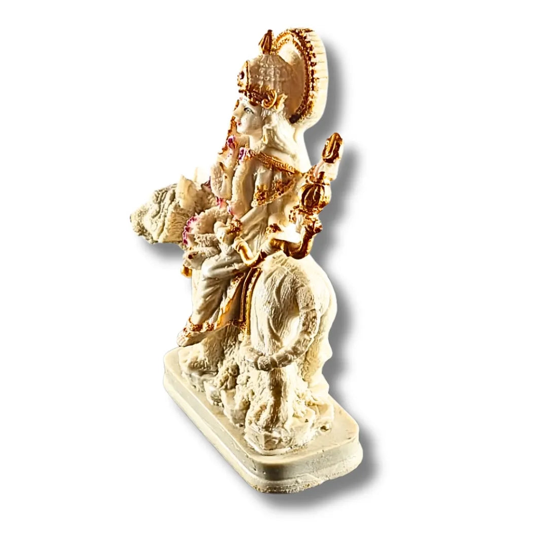 A small decorative statue of a seated Hindu deity on a cloud, made of cream-colored stone or resin with gold-toned detailing and small pink accents, shown on a plain white background.