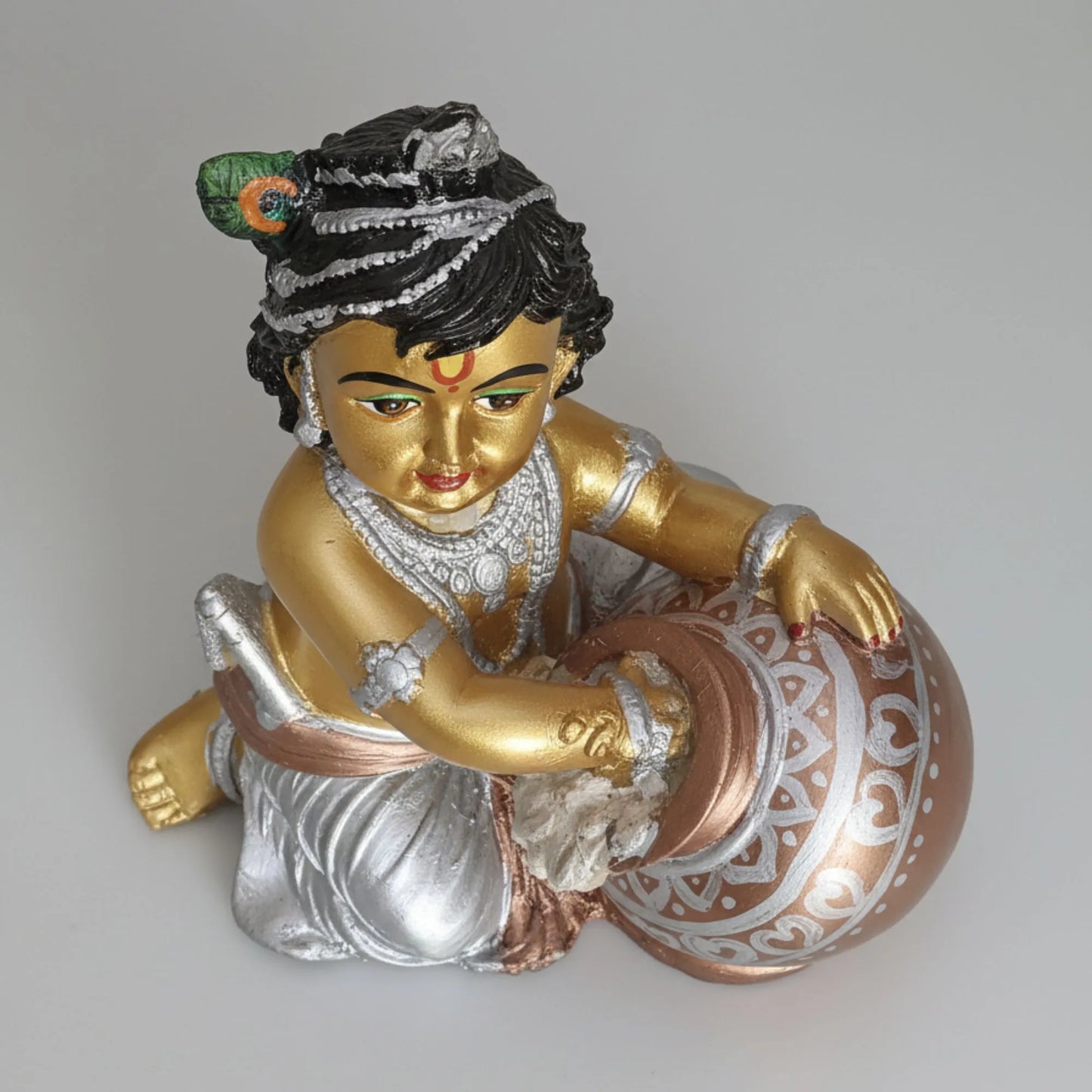 Statue of a deity holding a drum on a plain background