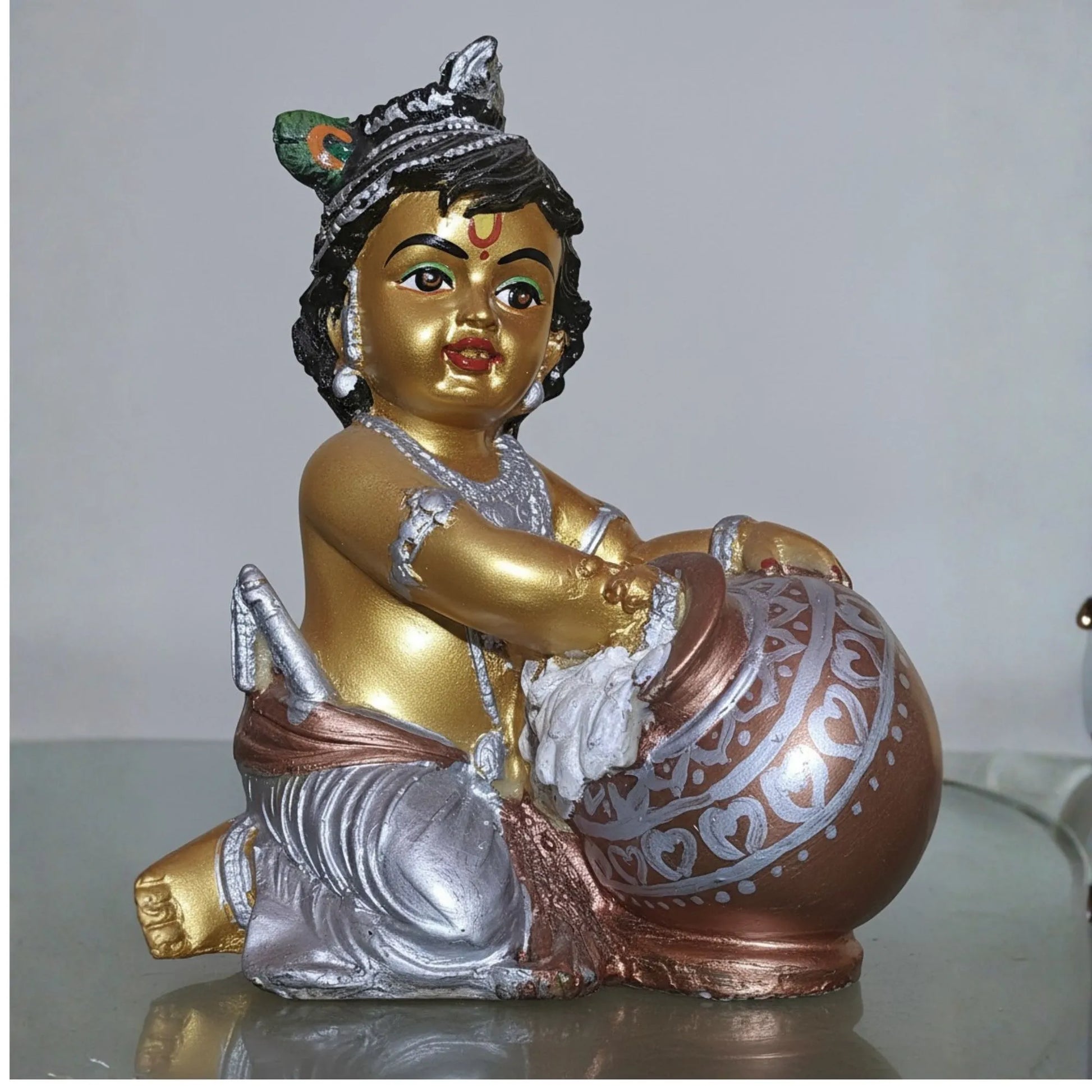 Decorative statue of a child holding a drum on a plain background