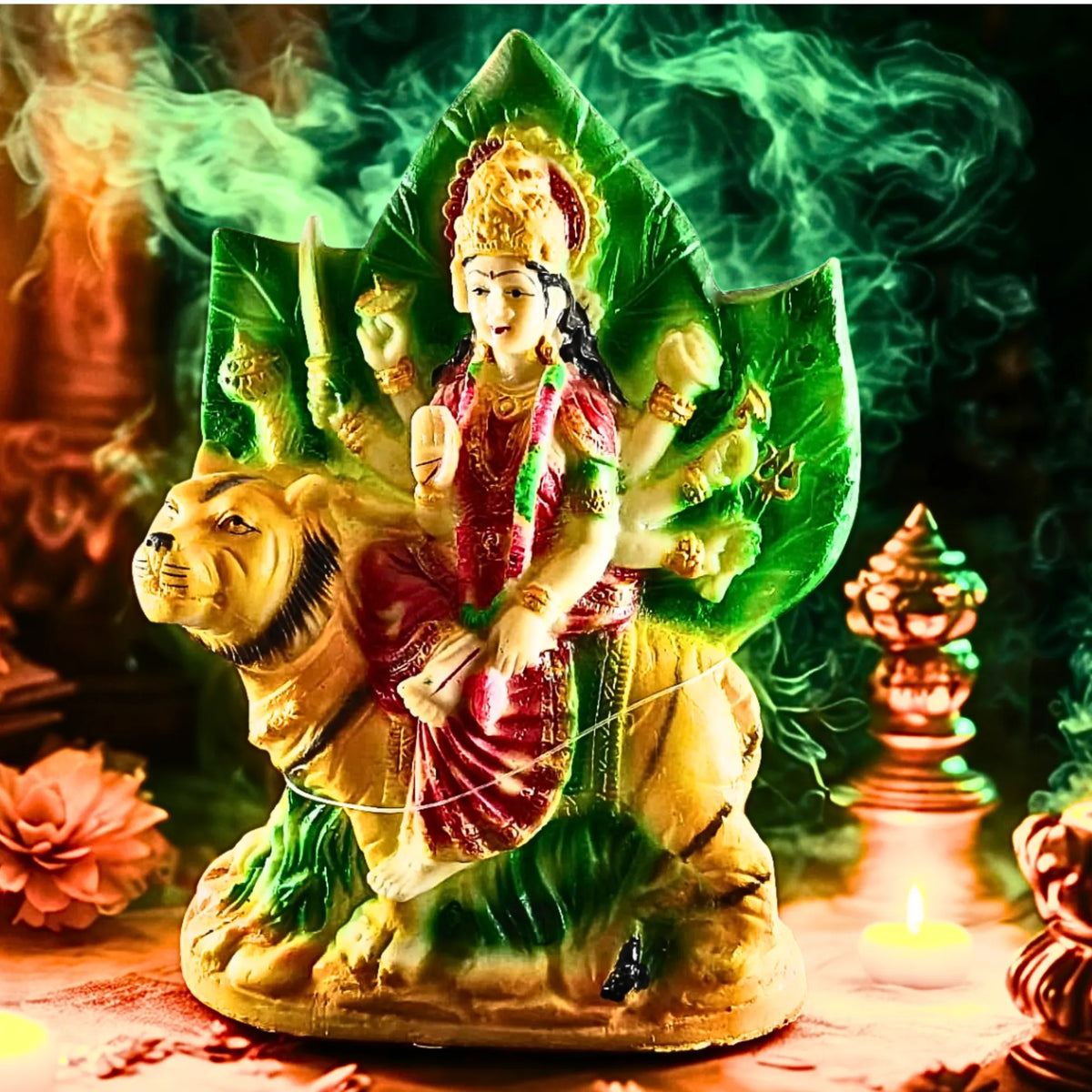 A colorful statue of a multi-armed goddess riding a lion, set against a smoky green and orange background with decorative elements.