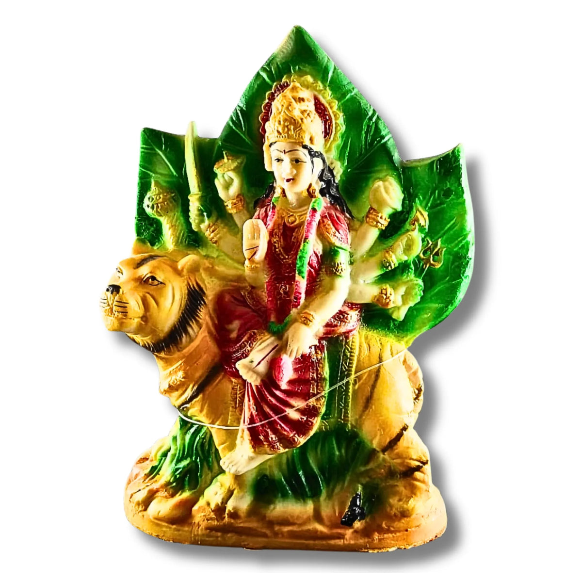 A colorful religious figurine of the Hindu goddess Durga  riding a Lion, set against a green leaf-shaped backdrop on a plain white background.