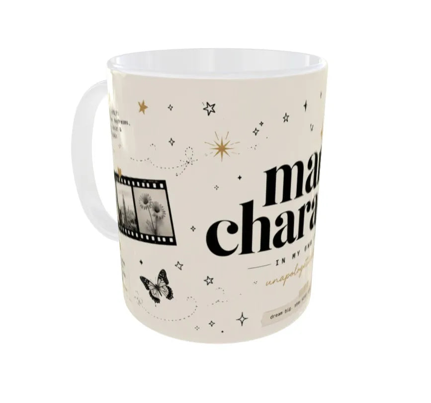 An off-white ceramic mug with a black and gold graphic print featuring the text 'magnificent' in a stylized font, stars, a film strip, and a butterfly, shown on a plain white background.