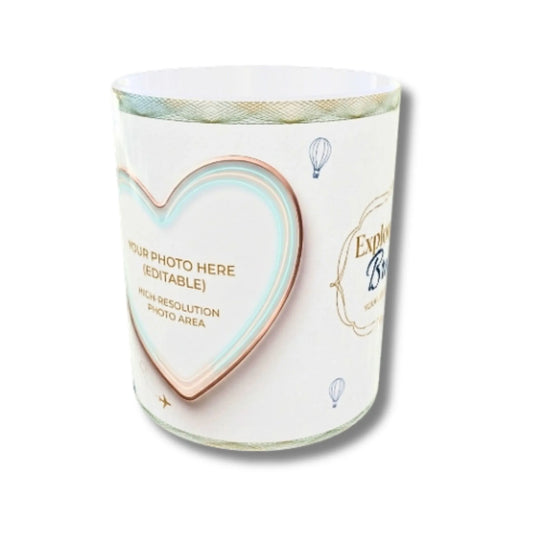 A white cylindrical candle jar with a decorative label featuring a large heart outline, gold placeholder text, and small hot air balloon illustrations.