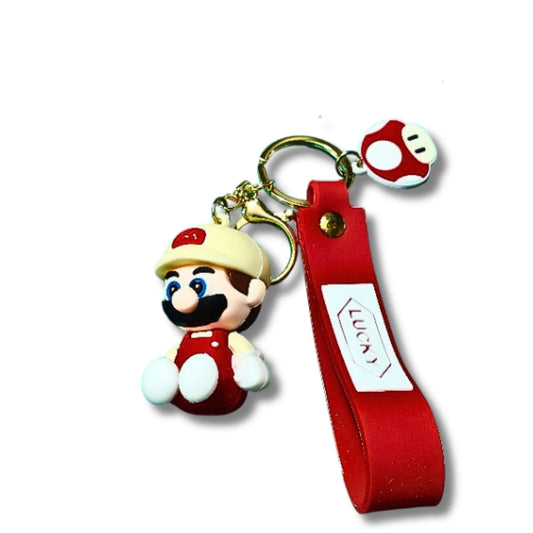 A Super Mario keychain featuring a 3D character charm of Mario, a red fabric wrist strap with a white label, and a small red-and-white mushroom keyring on a white background.