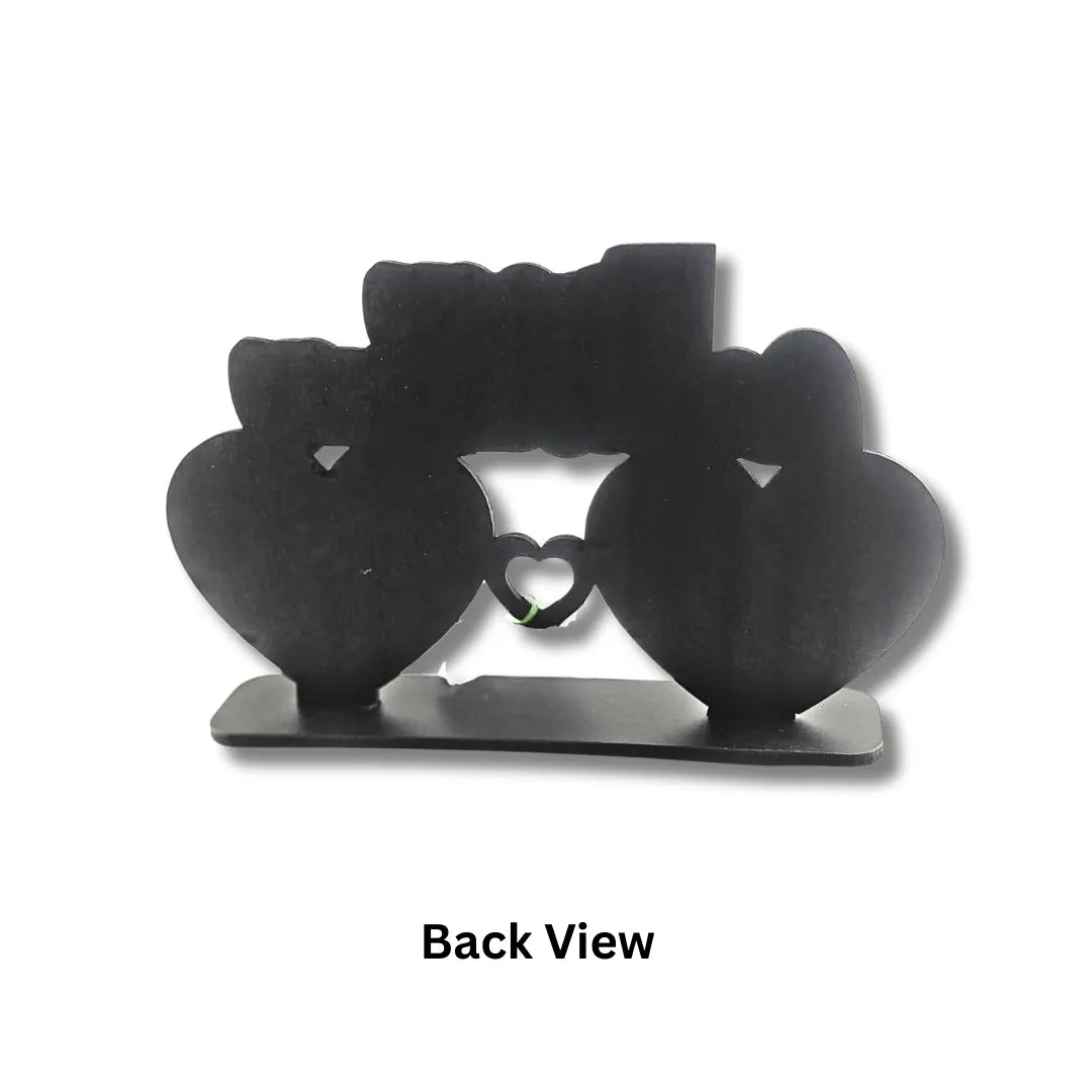 Black metal decorative item shaped like a heart with a central cutout, on a white background.