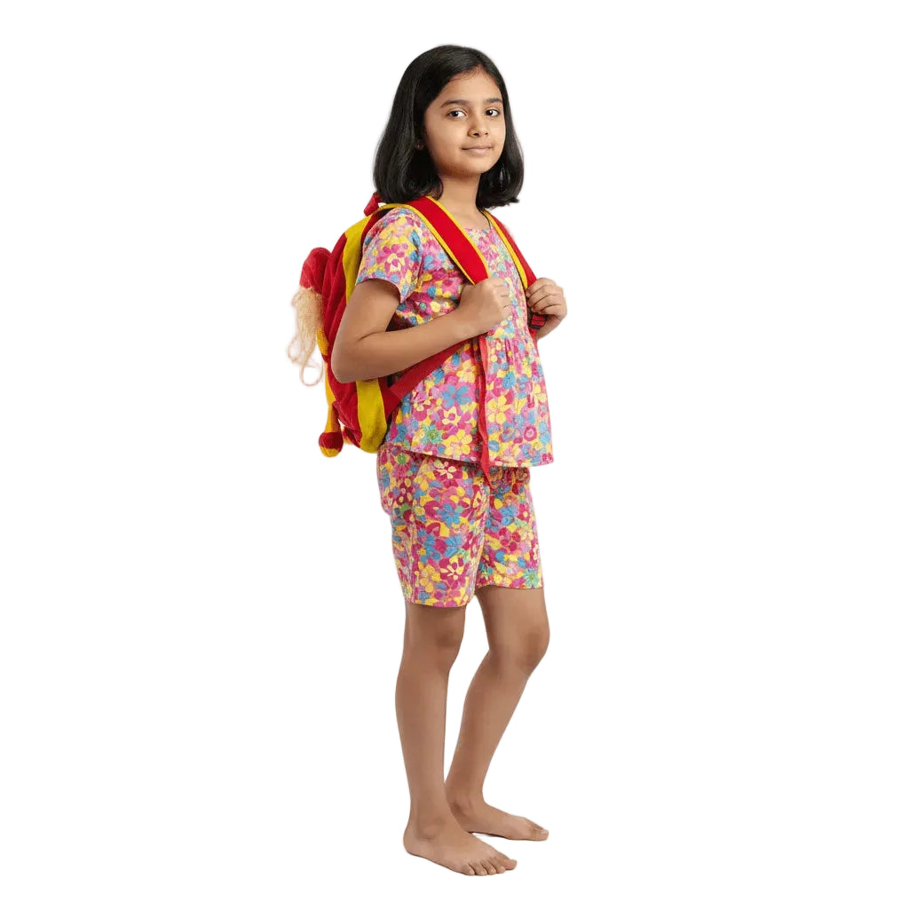 Young girl wearing a colorful outfit with a backpack on a white background