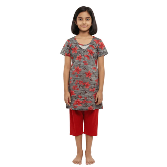 Young girl wearing a gray floral top and red shorts on a white background