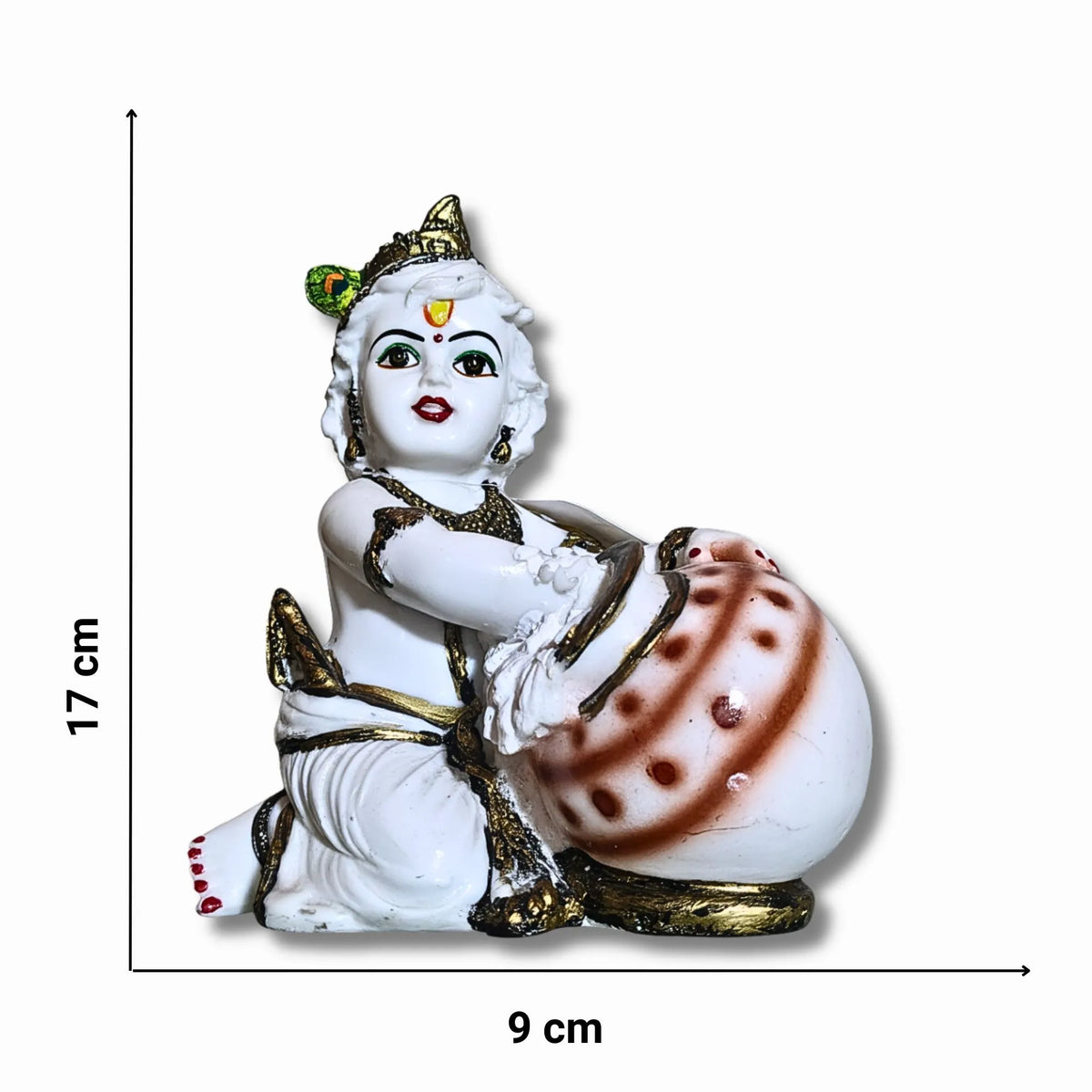A small white figurine of a seated child deity with gold detailing and a brown patterned drum, shown on a white background with dimension markers indicating 17 cm height and 9 cm width.