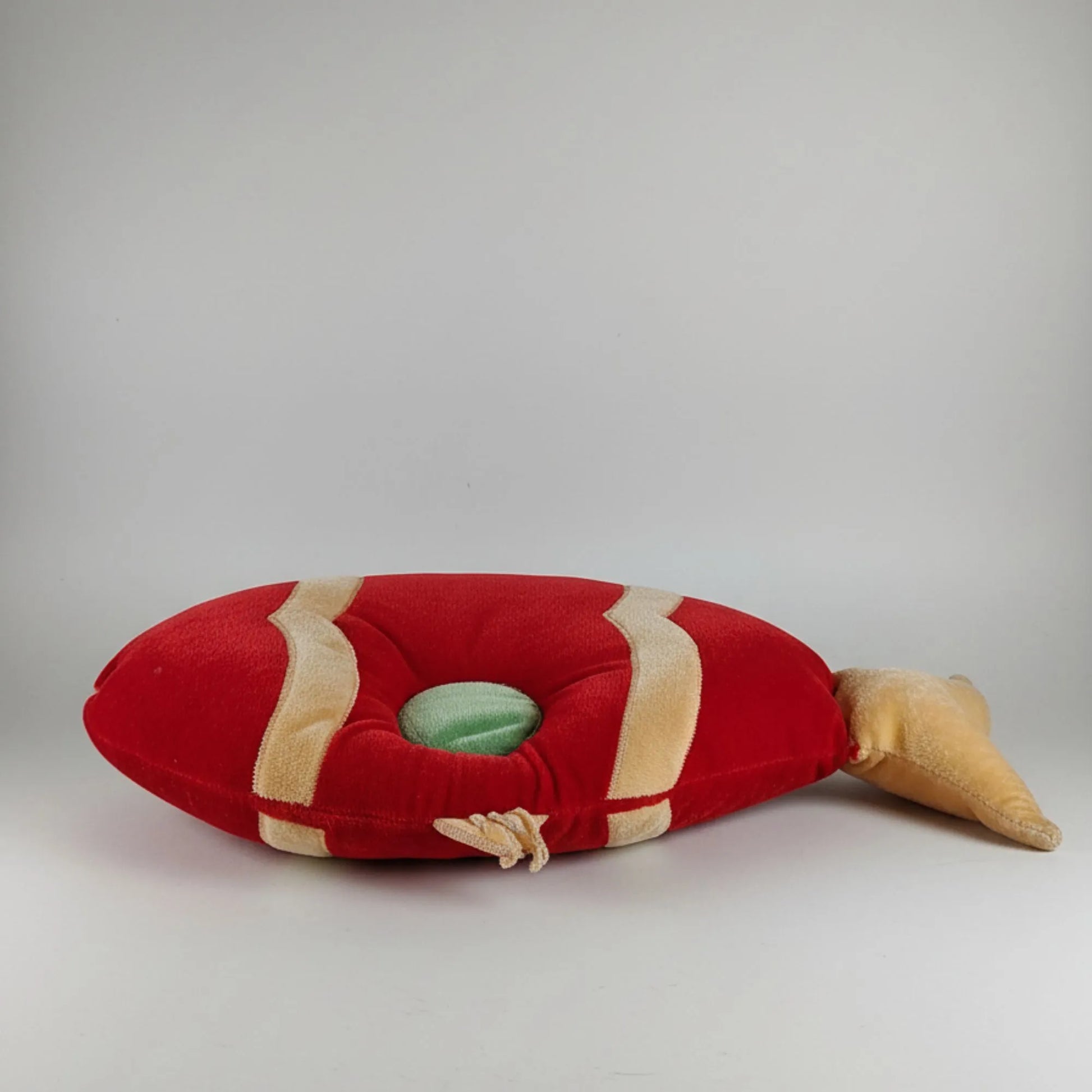 Red and beige plush toy resembling a lobster on a light gray background