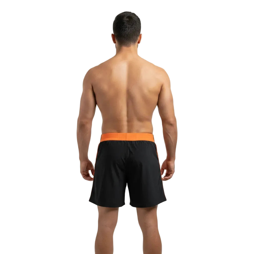 Man wearing black swim shorts with orange waistband on a white background