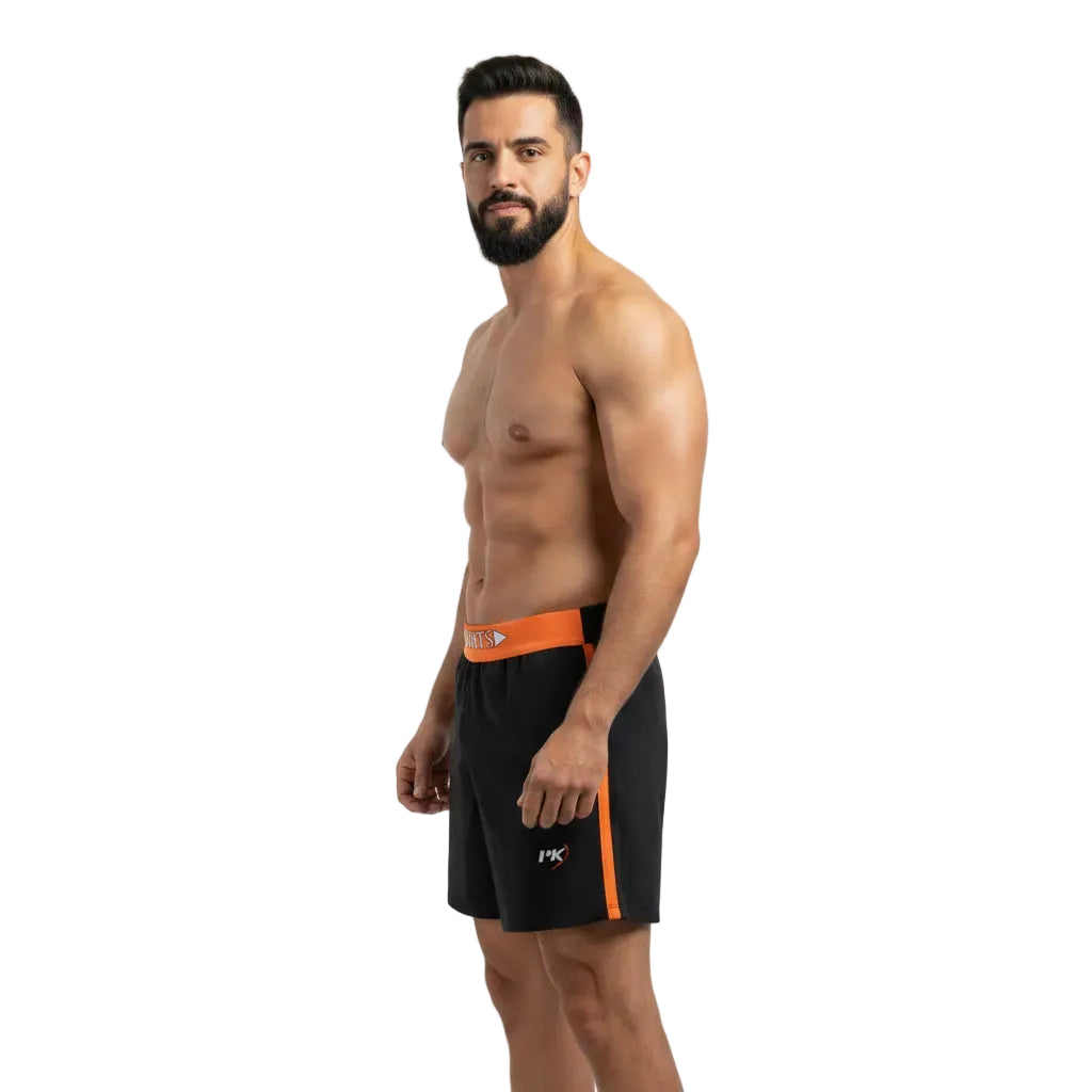 Man wearing black swim shorts with orange accents on a white background