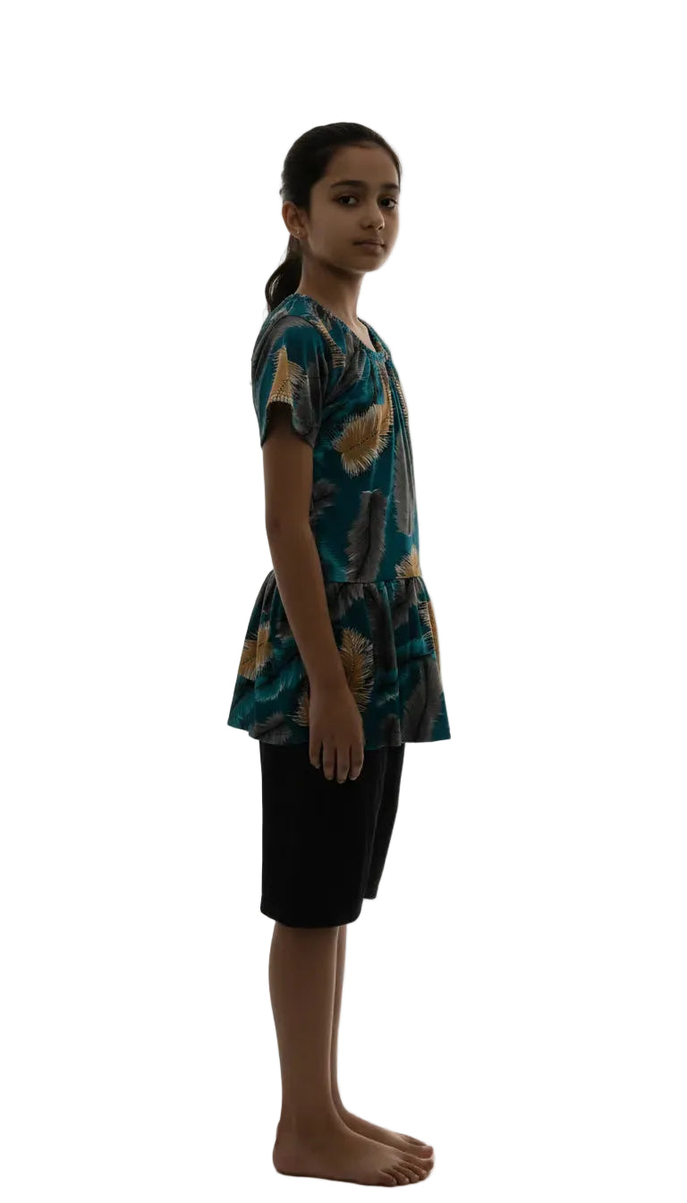 Person wearing a patterned shirt and black shorts on a white background