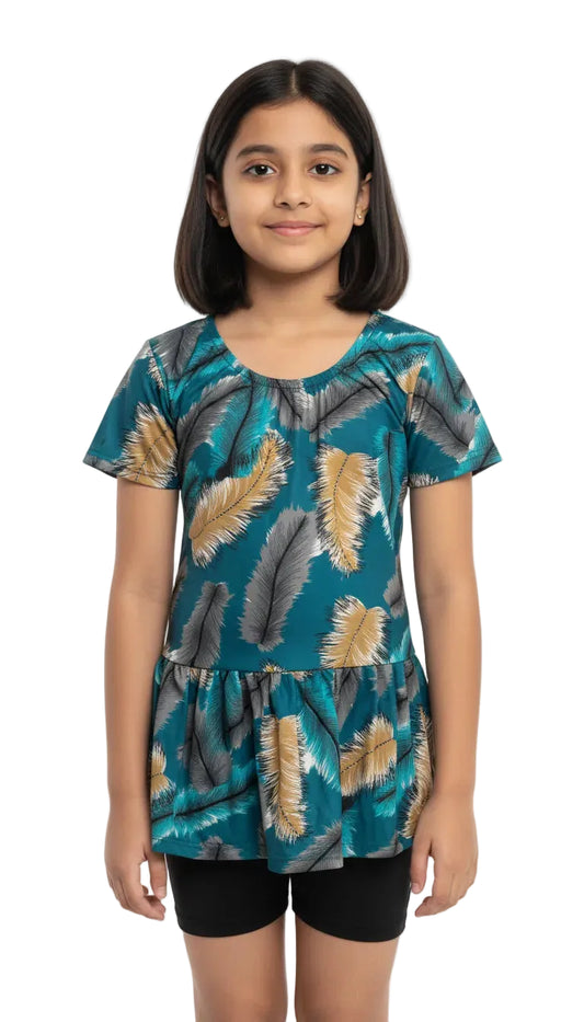 Young girl wearing a teal top with leaf pattern on a white background