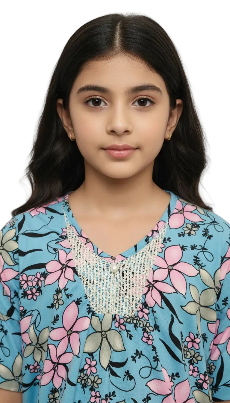 Young girl wearing a floral dress with a beaded neckline against a white background